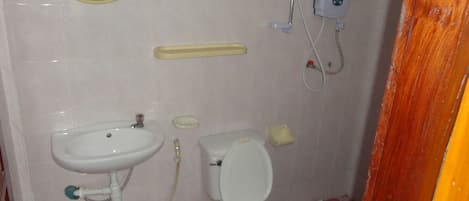A bathroom with a sink, toilet, and a mirror.