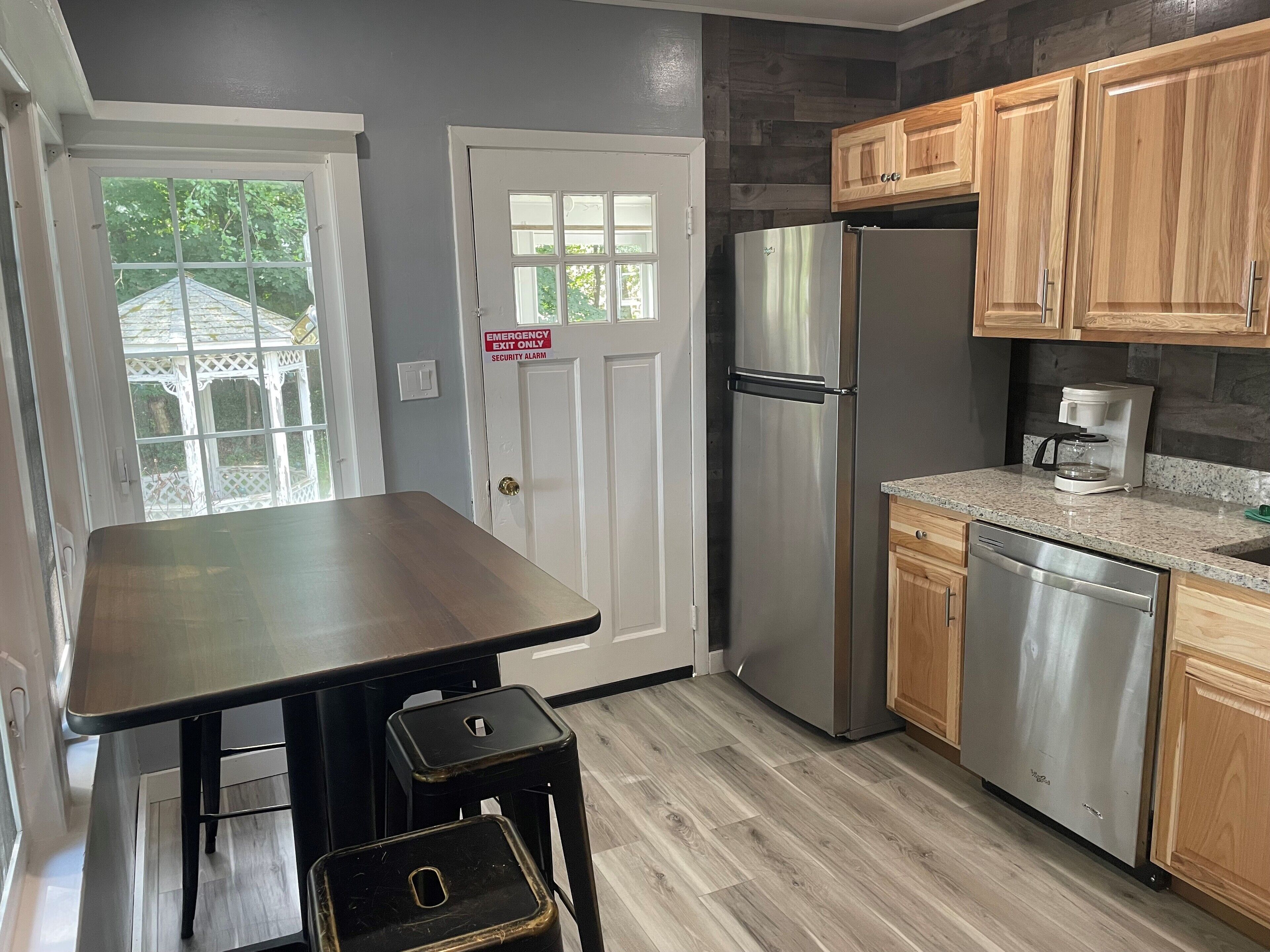 A modern kitchen with wooden cabinets, stainless steel appliances, and a large countertop.