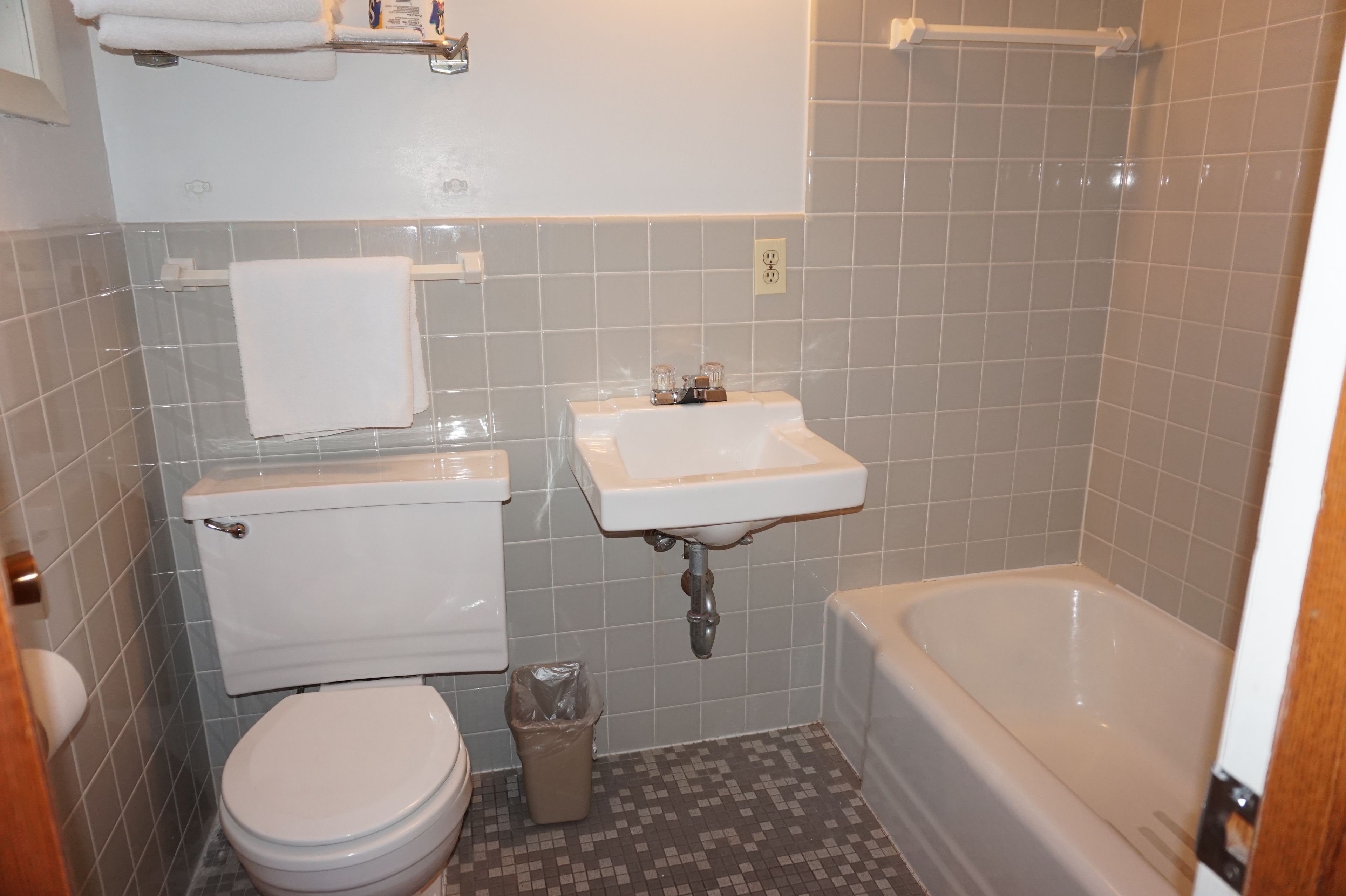 Une petite salle de bain avec des toilettes, un lavabo et une baignoire.