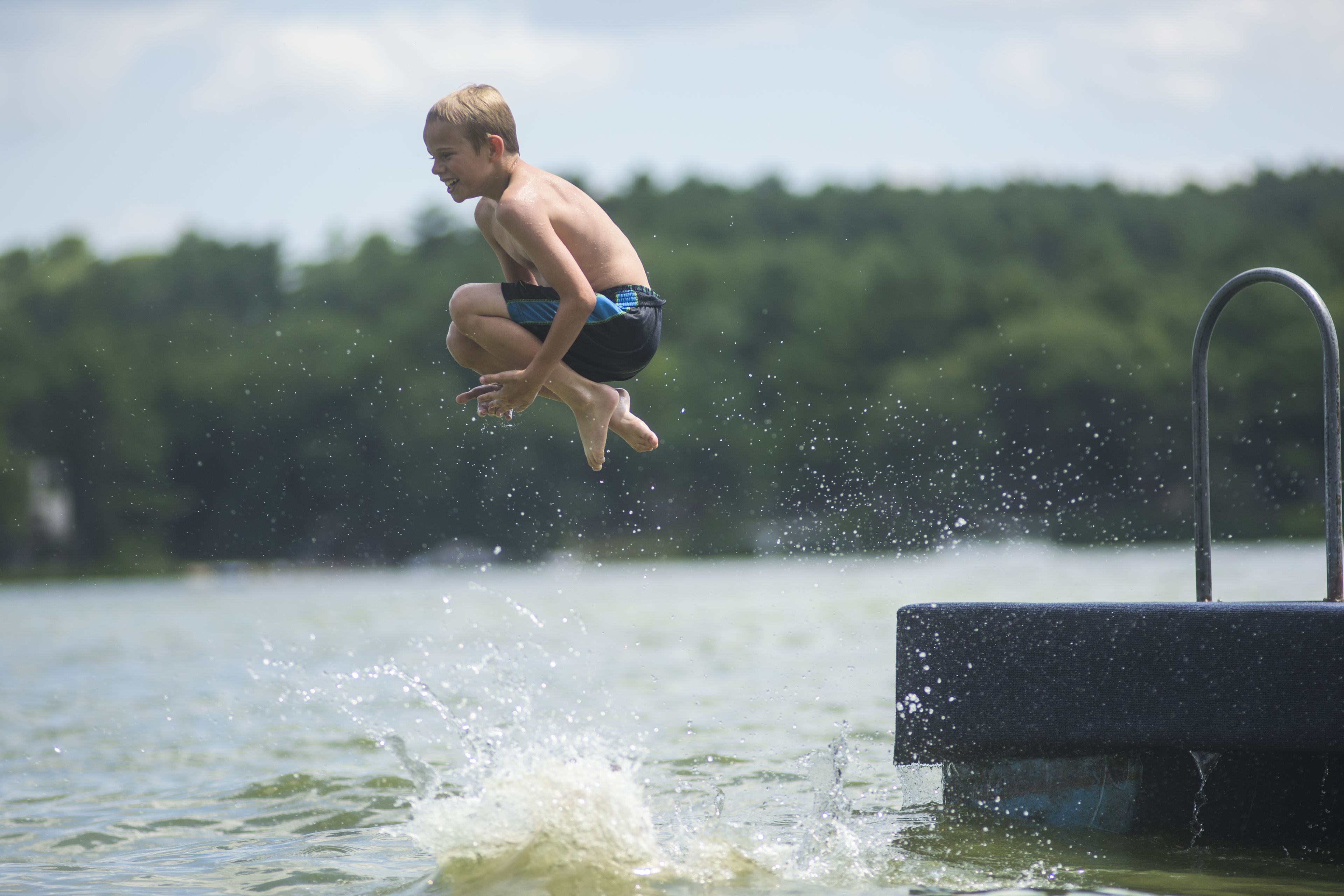 Eine Person springt in ein Schwimmbecken.