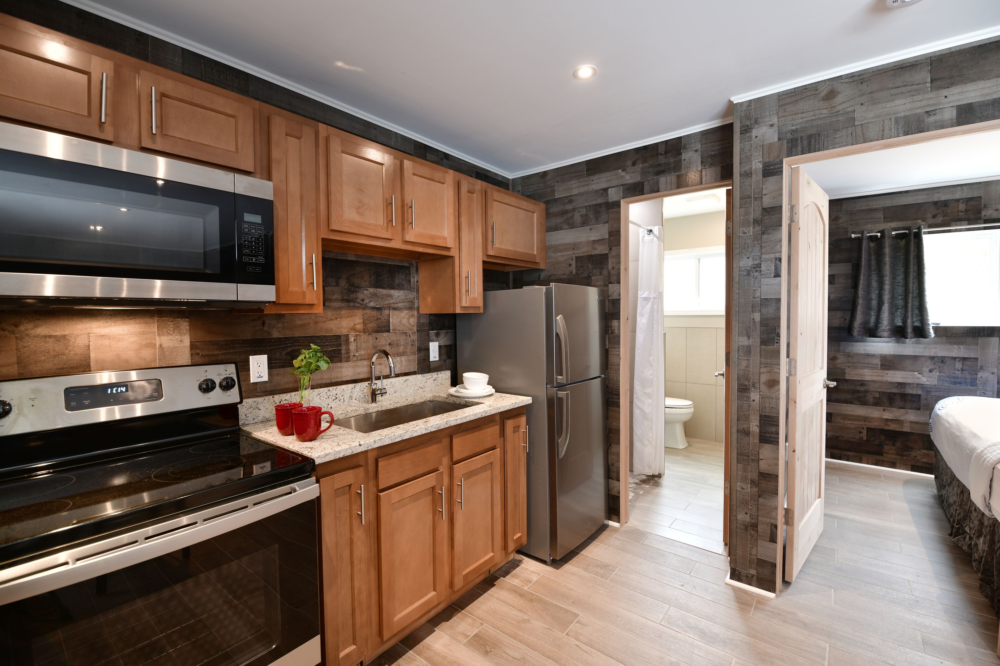 A modern kitchen with wooden cabinets, stainless steel appliances, and a granite countertop.
