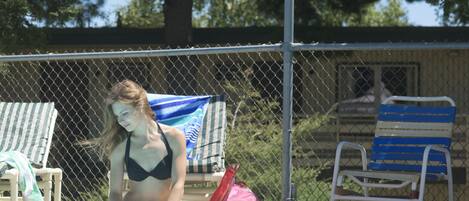 Piscina a l'aire lliure de temporada, para-sols i gandules