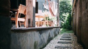 A pathway with wooden steps leading to a seating area with wooden chairs and a hammock. - Hueandin Klinmai Boutique Hotel (Chiang Mai)