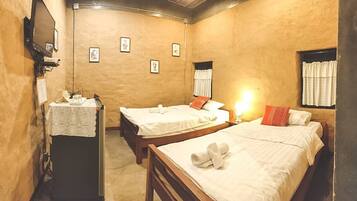 Ein Zimmer mit zwei Betten, einem Schreibtisch mit Lampe und gerahmten Bildern an der Wand.