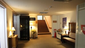 A hotel lobby with a staircase, a reception desk, and a seating area. - Charade Inn Shiga (Yamanouchi)