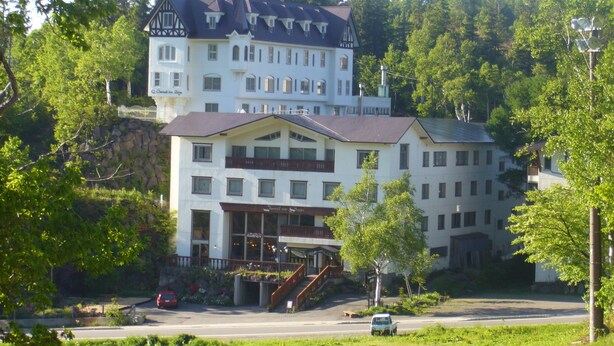 A large, multi-story building with a prominent balcony and a staircase leading to the entrance. - Charade Inn Shiga (Yamanouchi)