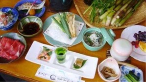 A table with various dishes, including vegetables, meat, and drinks, suggesting a meal setting. - Charade Inn Shiga (Yamanouchi)