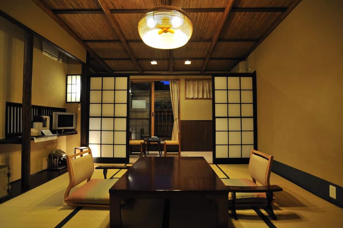 A traditional Japanese room with tatami flooring, a low table, and sliding doors.