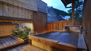 A wooden hot tub with a bench, surrounded by a wooden deck and bamboo walls. - Shibu Onsen KOKUYA (Yamanouchi)