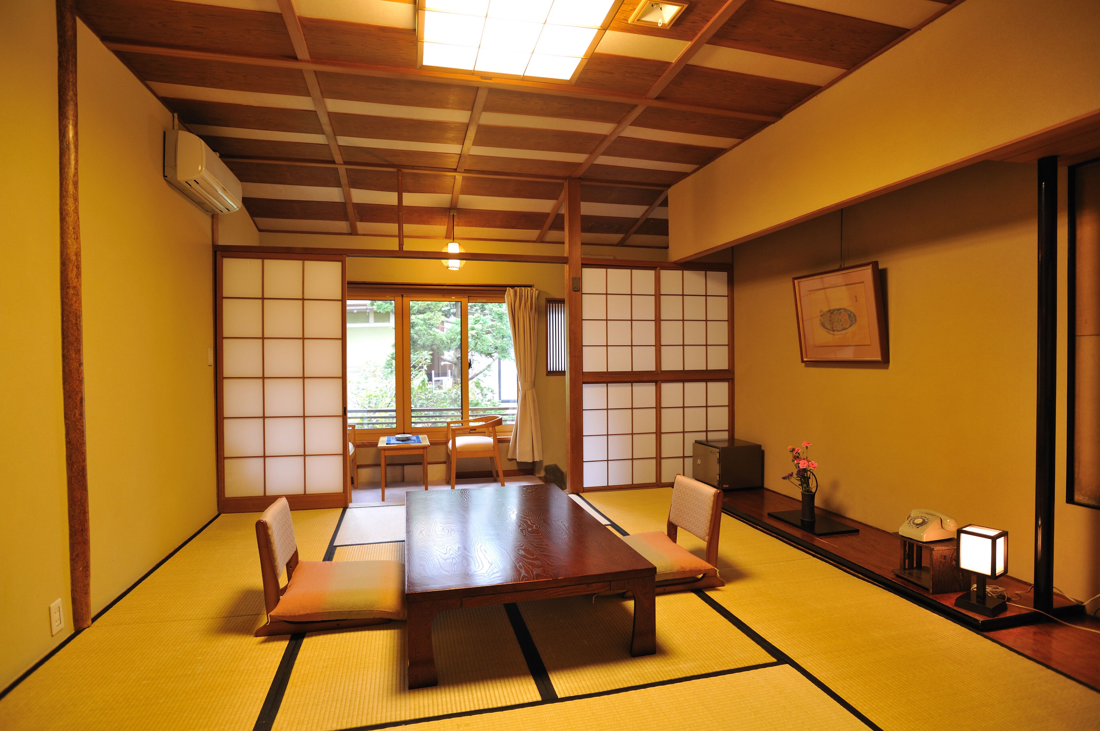 Een traditionele Japanse kamer met tatami vloerbedekking, een lage tafel en shoji schermen.