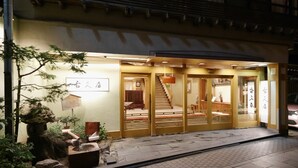A traditional Japanese inn with a wooden exterior, a stone water feature, and a staircase leading to the entrance. - Shibu Onsen KOKUYA (Yamanouchi)