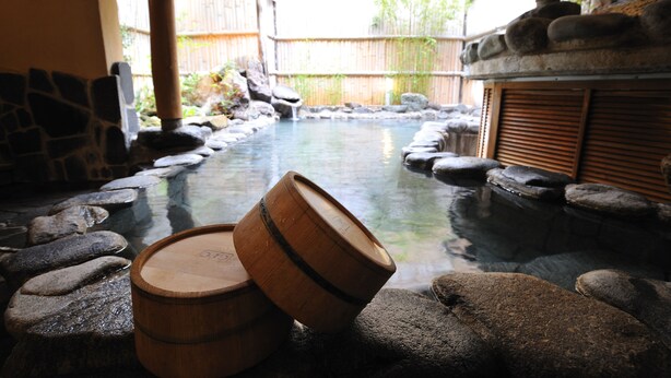 A traditional Japanese onsen with stone baths and wooden barrels. - Shibu Onsen KOKUYA (Yamanouchi)