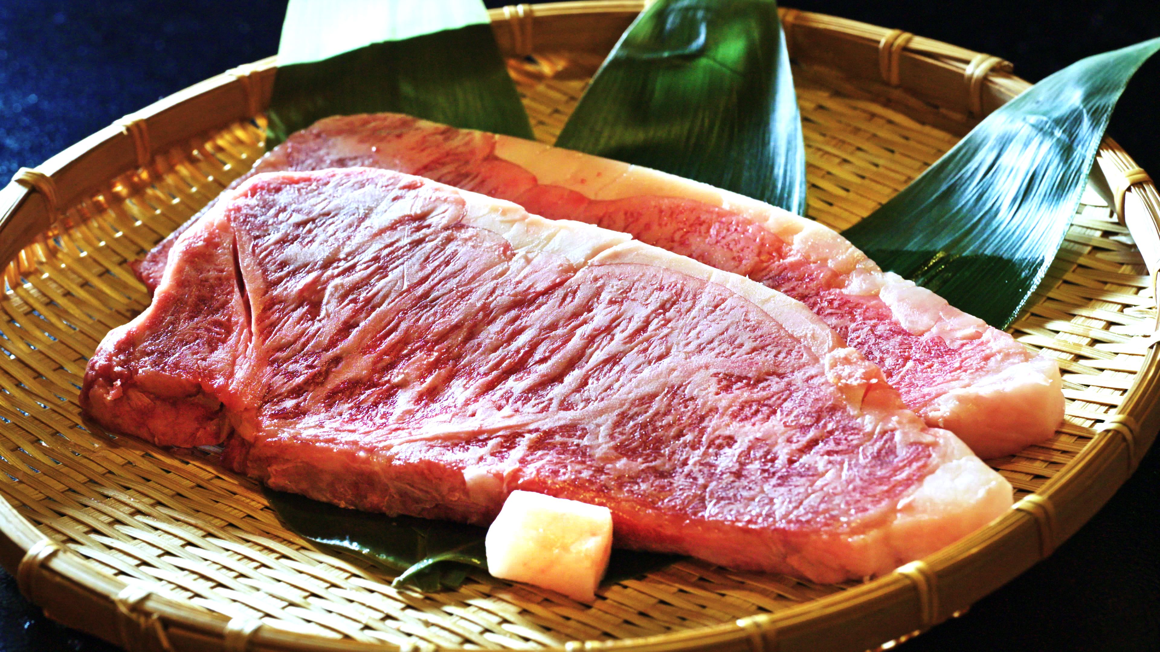 A woven basket containing raw meat and a small block of cheese.