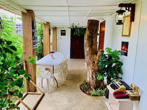 A room with a white table and chairs, a wooden tree trunk, and a wall-mounted telephone. - The Orient Beach Boracay (Boracay Island)