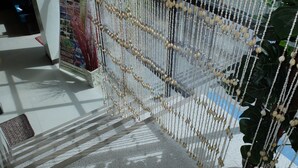 A staircase with a decorative beaded curtain, a sign for 'The Orient Beach Bungalows', and a 'Helmet Diving' advertisement. - The Orient Beach Boracay (Boracay Island)