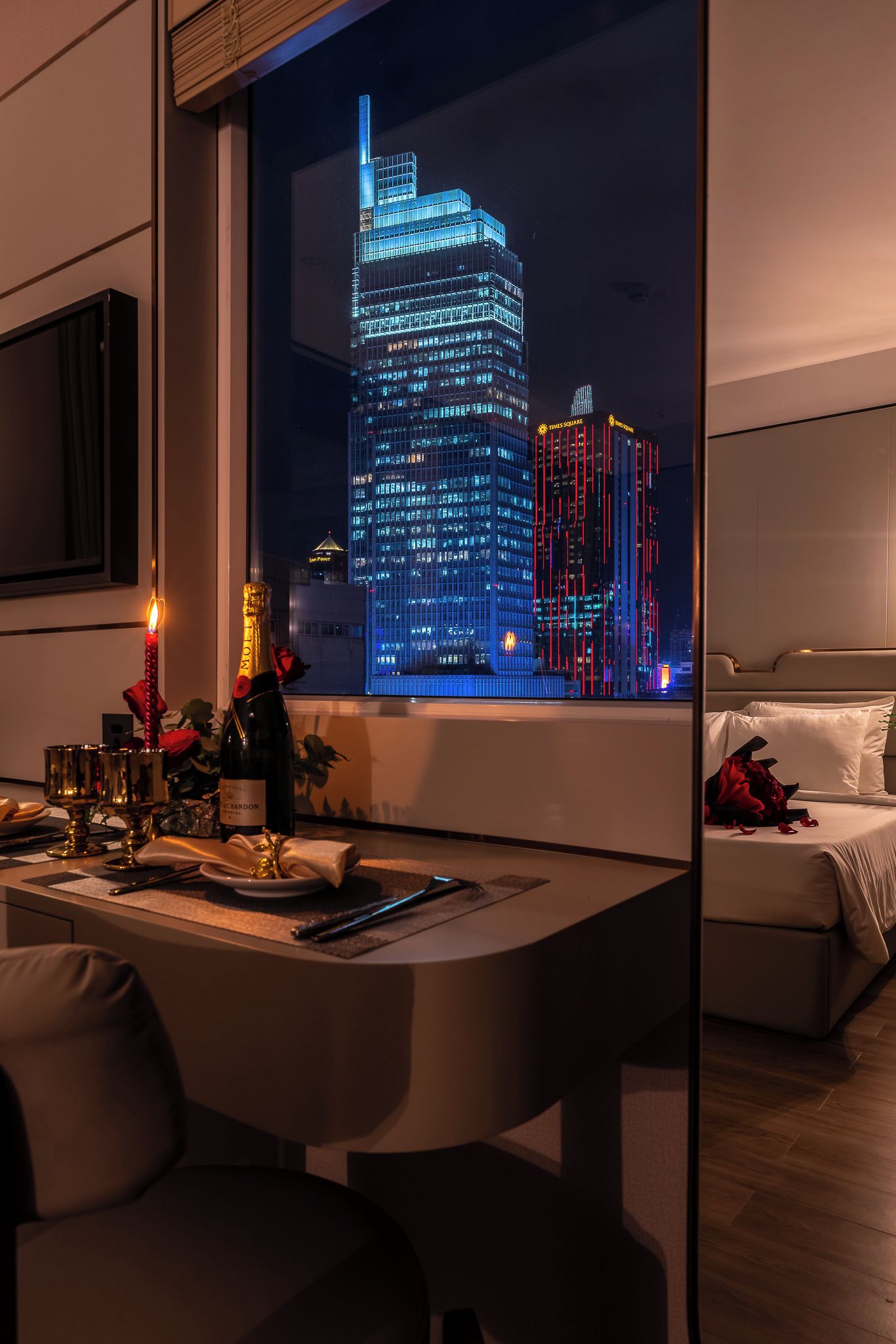 A modern dining area with a view of a cityscape at night, including a Times Square building.