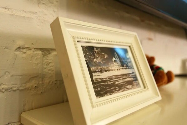 A framed photograph on a shelf against a textured wall. - OwlStay GreenVilla (Shoufeng)