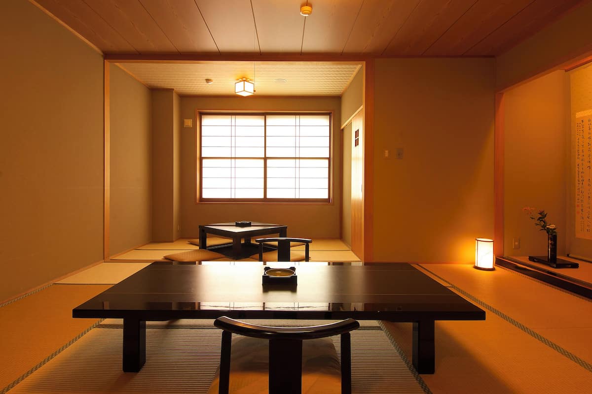 Ein traditioneller japanischer Raum mit Tatami-Boden, einem niedrigen Tisch und einer Schiebetür.