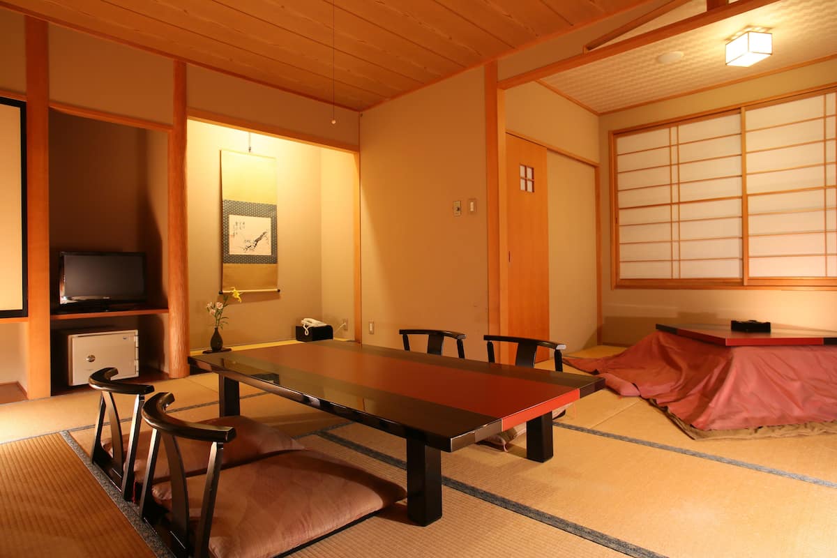 Ein traditioneller japanischer Raum mit Tatami-Boden, einem niedrigen Tisch und Schiebetüren.