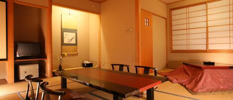 A traditional Japanese-style room with tatami flooring, a low table, and sliding doors.