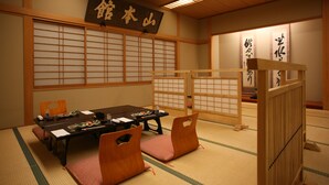 Una habitación japonesa tradicional con suelo de tatami, una mesa baja y sillas de madera.