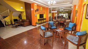 A hotel lobby with a staircase, seating area, and a reception desk. - One Averee Bay Hotel (Coron)