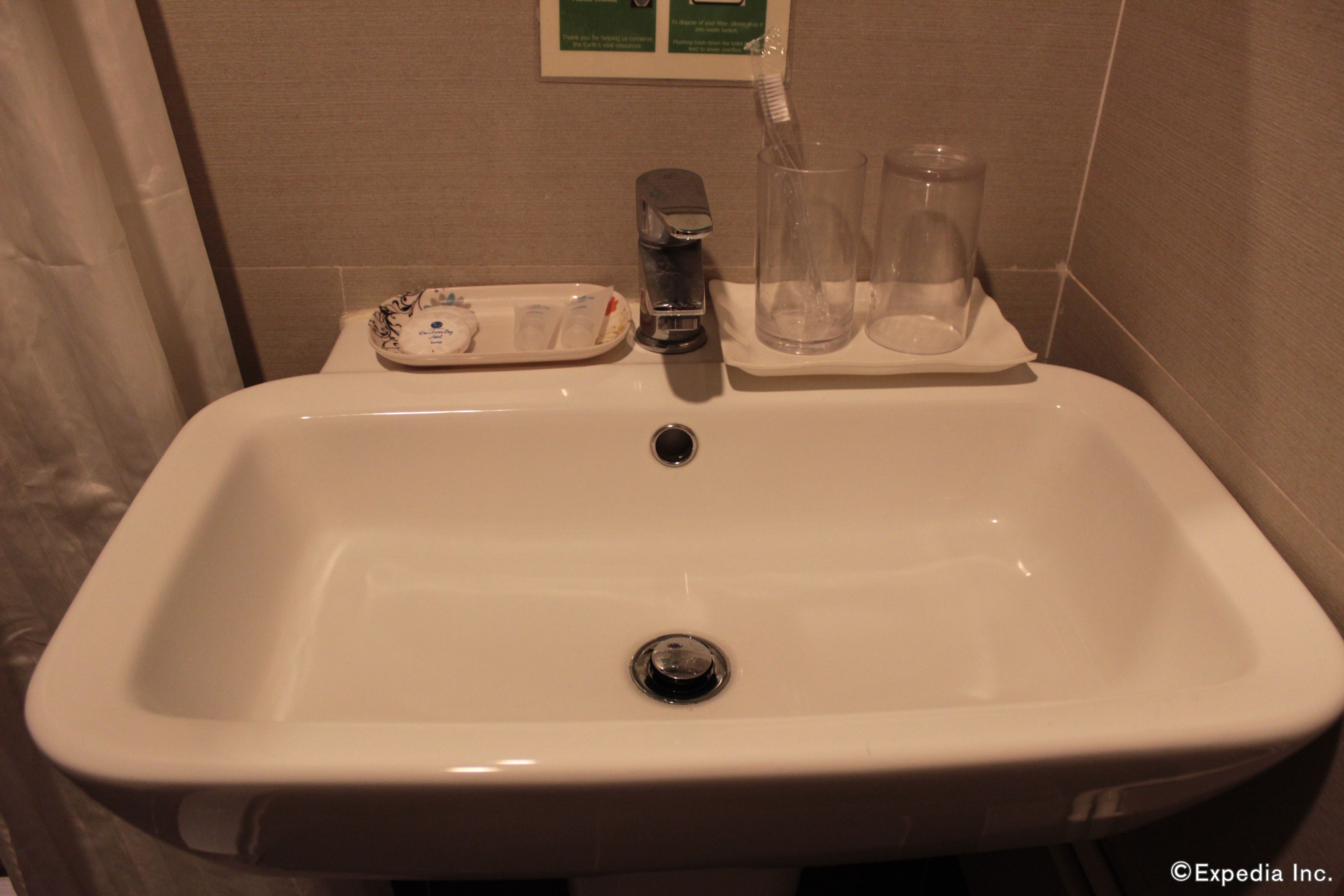 Un lavamanos con jabonera, portalápices para cepillos de dientes y dos vasos.