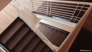 A staircase with a white metal railing and wooden steps. - One Averee Bay Hotel (Coron)