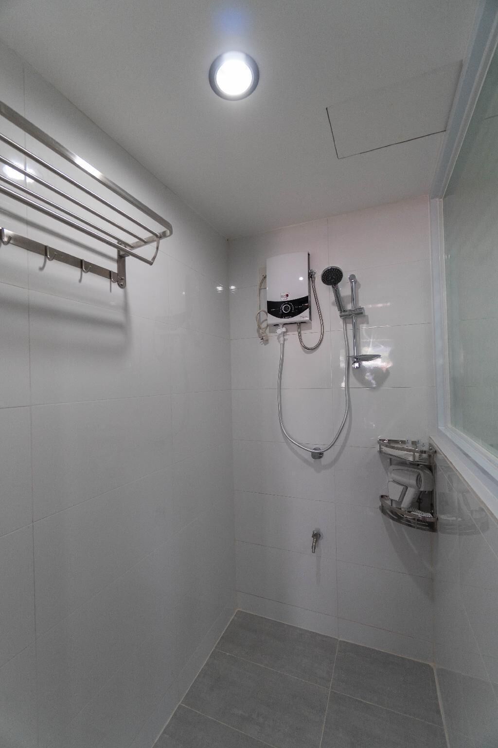 A modern bathroom with a shower, a towel rack, and a toilet.