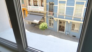 Blick auf eine Straße mit Gebäuden, darunter eine Druckerei und ein Schild in einer fremden Sprache.