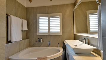 A modern bathroom with a freestanding bathtub, a sink, and a large mirror.