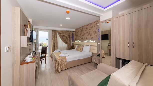 Una habitación de hotel moderna con cama, sofá, escritorio y televisión.