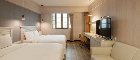 Une chambre d’hôtel avec deux lits, un bureau, une télévision et un canapé.