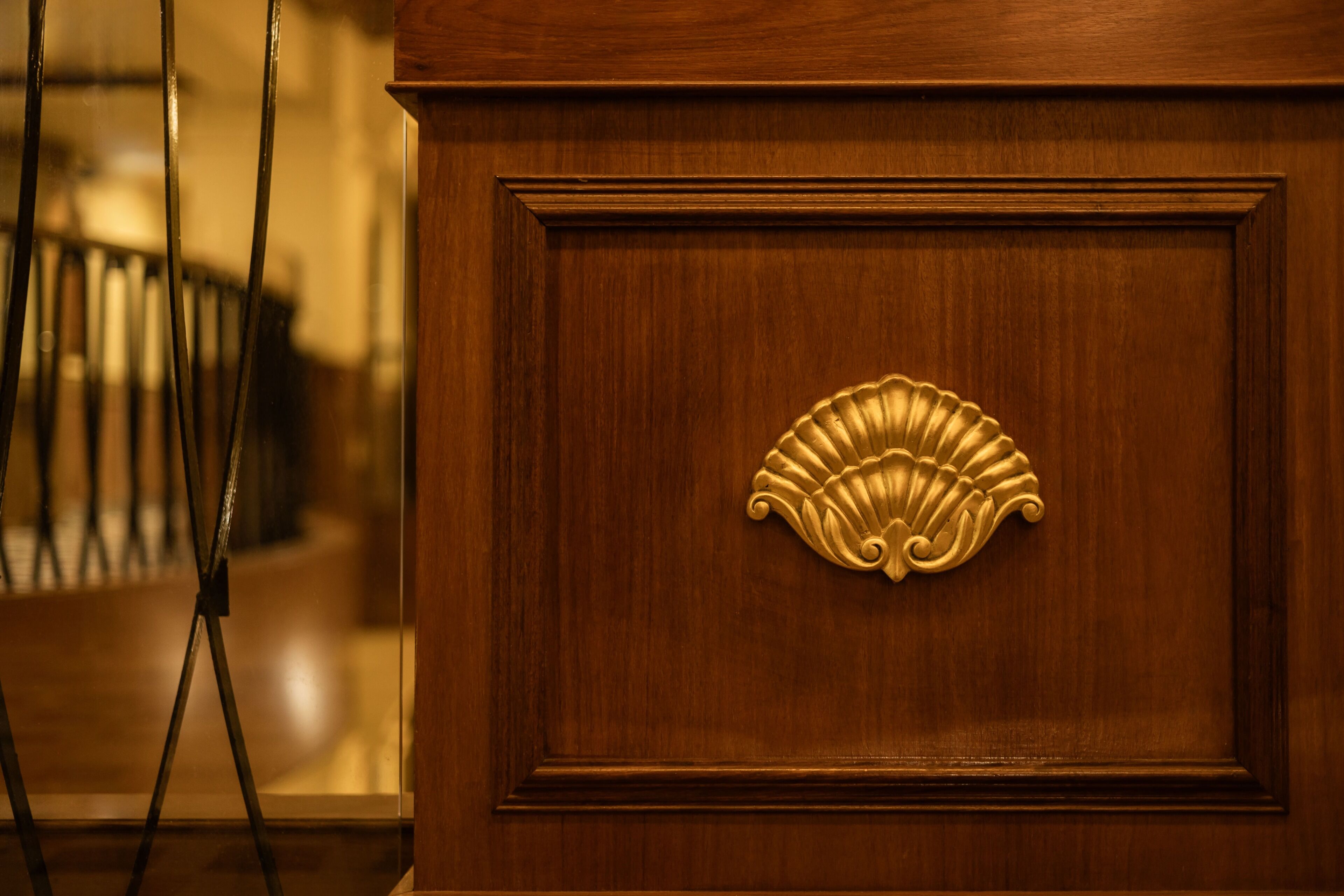 A wooden panel with a decorative brass handle.