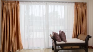 A room with a sofa, curtains, and a window. - Takanta Place (Udon Thani)