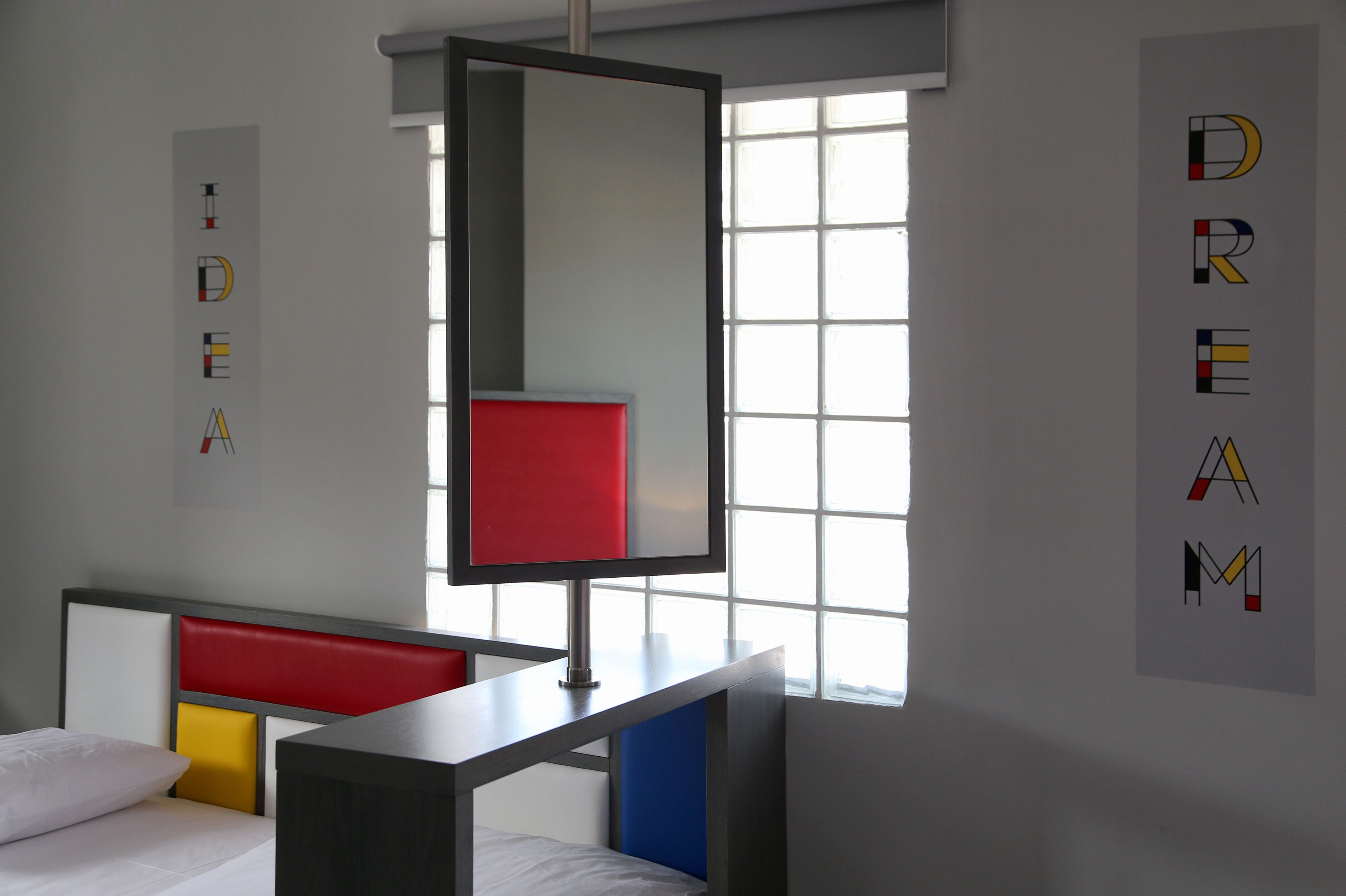 Ein modernes Hotelzimmer mit einem Bett, einem Schreibtisch und einem großen Fenster.