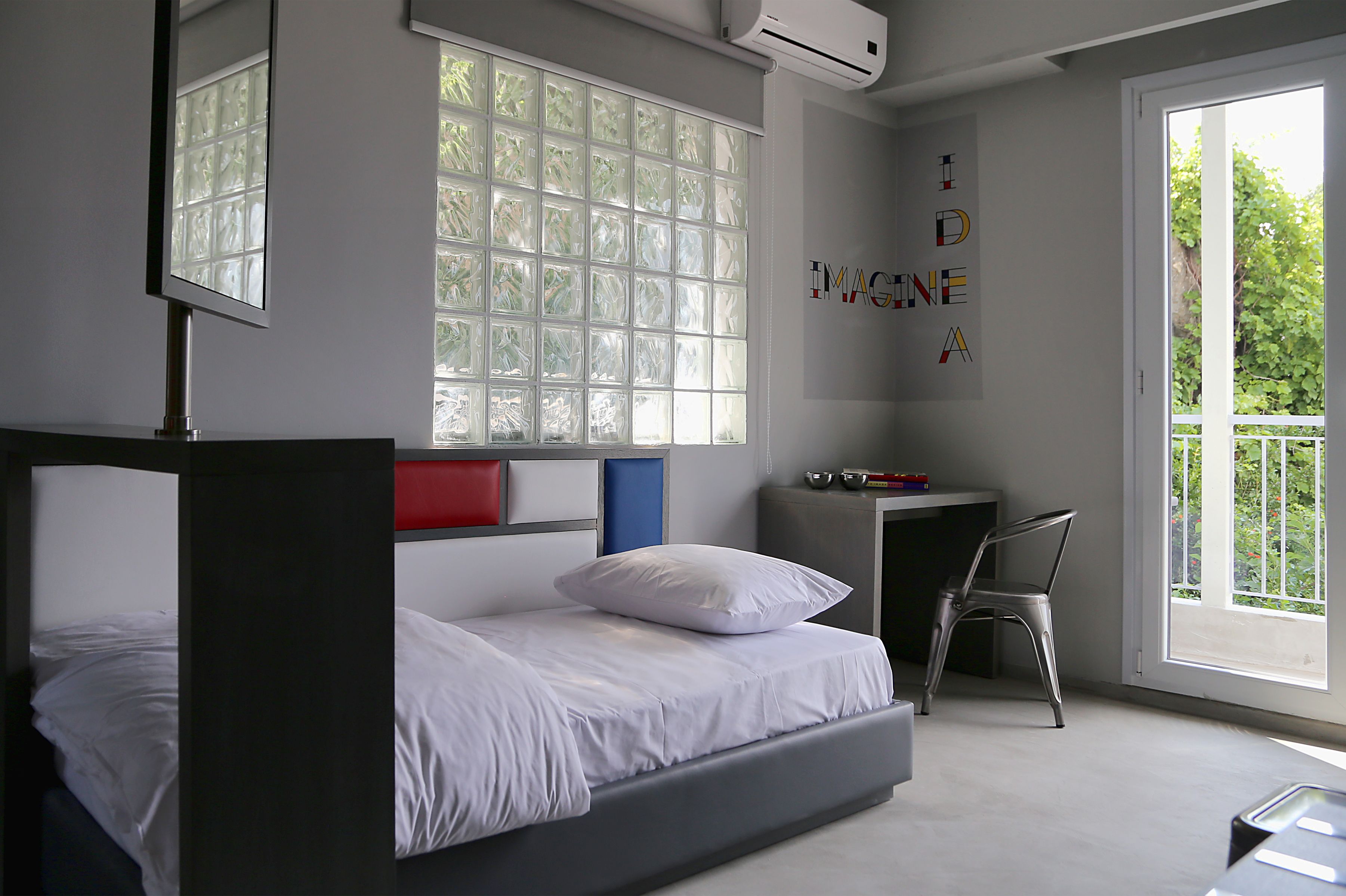 A modern bedroom with a bed, a desk, and a chair.