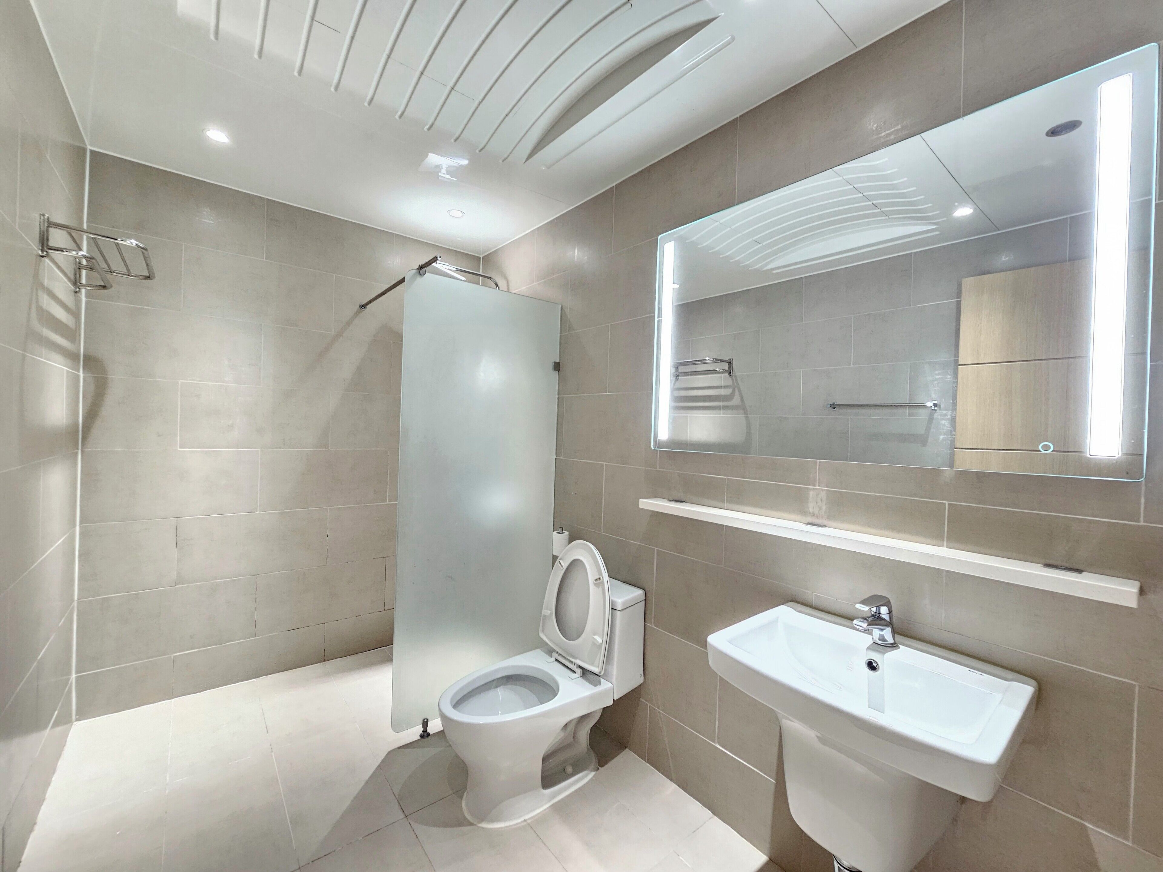 Un baño moderno con inodoro, lavamanos y ducha.