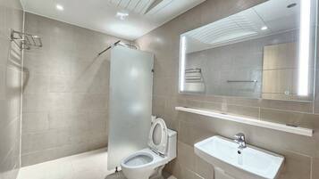 Un baño moderno con inodoro, lavamanos y ducha.
