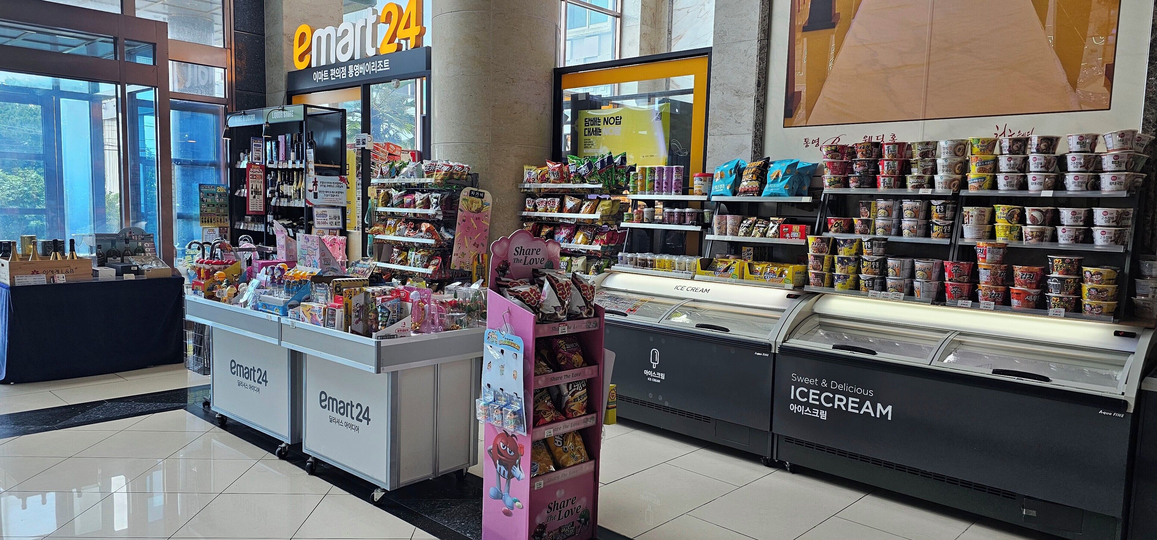 Una tienda de conveniencia abierta las 24 horas, con estantes llenos de aperitivos, bebidas y helados.