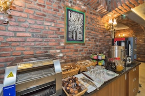 A breakfast bar with a brick wall, a zebra artwork, a coffee machine, and various food items. - Aprilis Gold Hotel - Special Class (Istanbul)