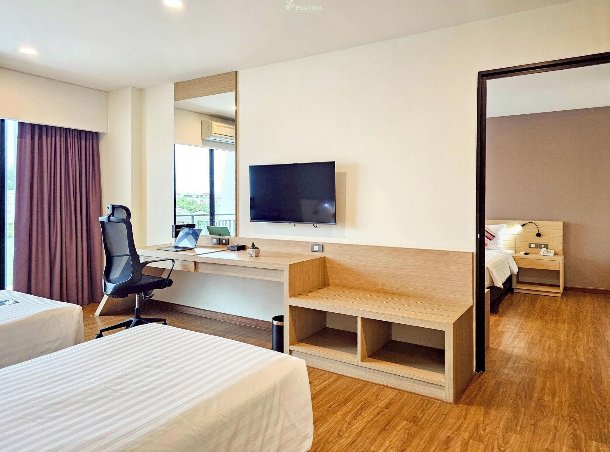 Une chambre d’hôtel équipée d’un lit, d’un bureau, d’une chaise, d’une télévision et d’un miroir.