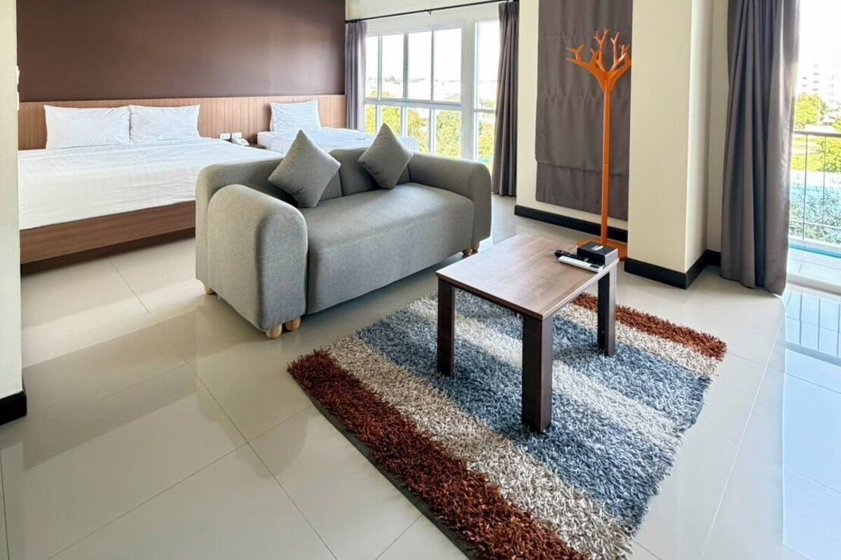 A modern living room with a sofa, a coffee table, and a large window.