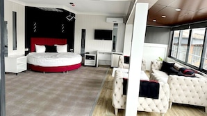 Una habitación de hotel moderna con una cama grande, un escritorio, un sofá y un televisor.