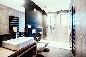 Suite Deluxe, varias camas | Baño | Ducha, secador de pelo, bidé y suelo radiante