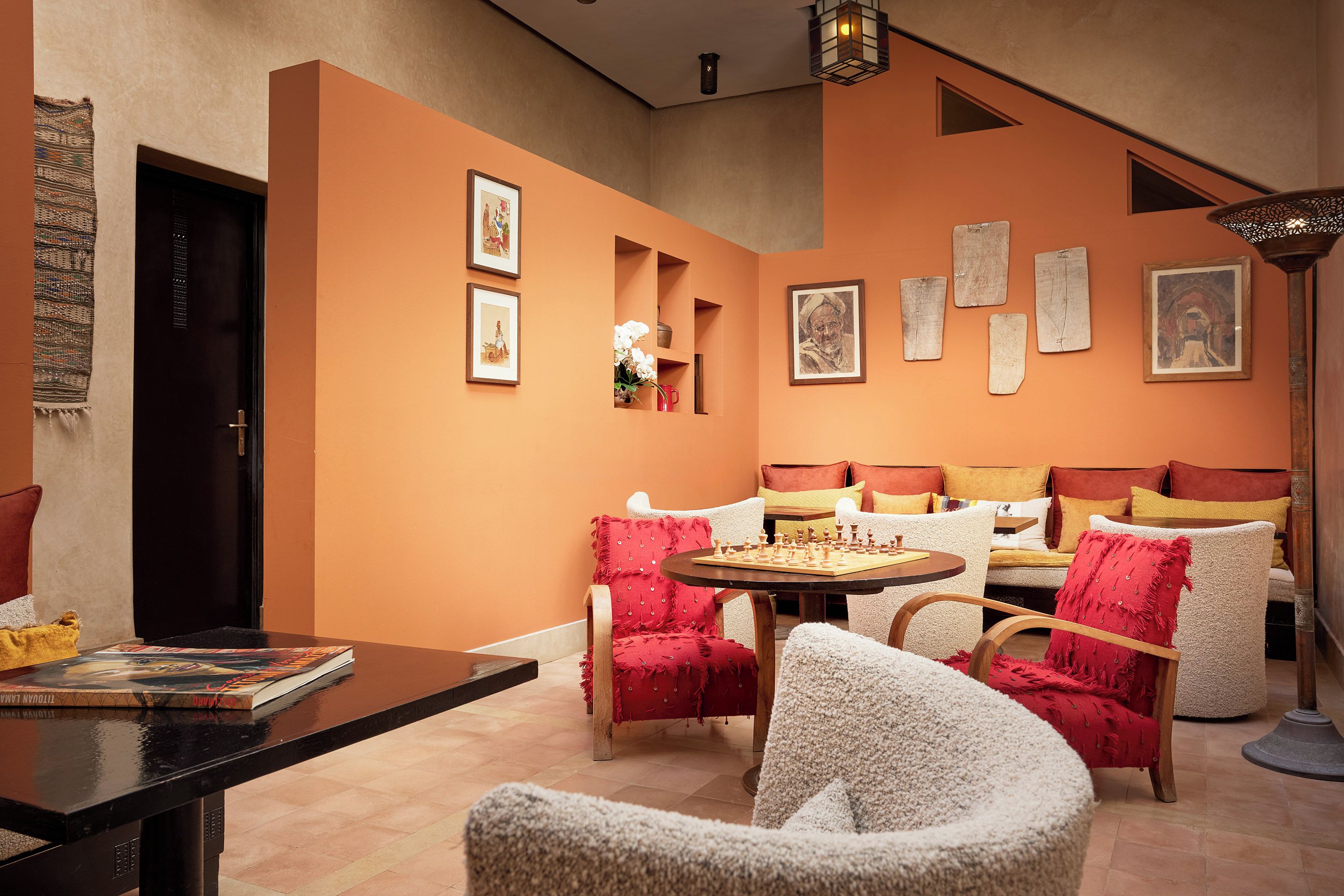 Una habitación con sofá, sillas, una mesa y obras de arte en las paredes.