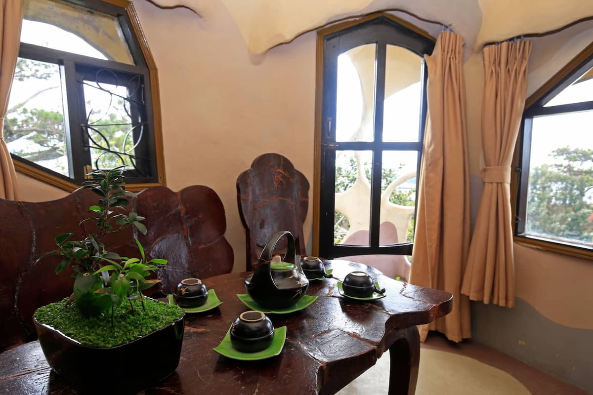 A rustic wooden table with green tea sets and a potted plant.