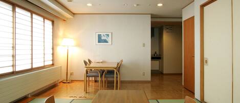 Una habitación tradicional japonesa con esteras de tatami, una mesa de madera baja y un panel de papel shoji.