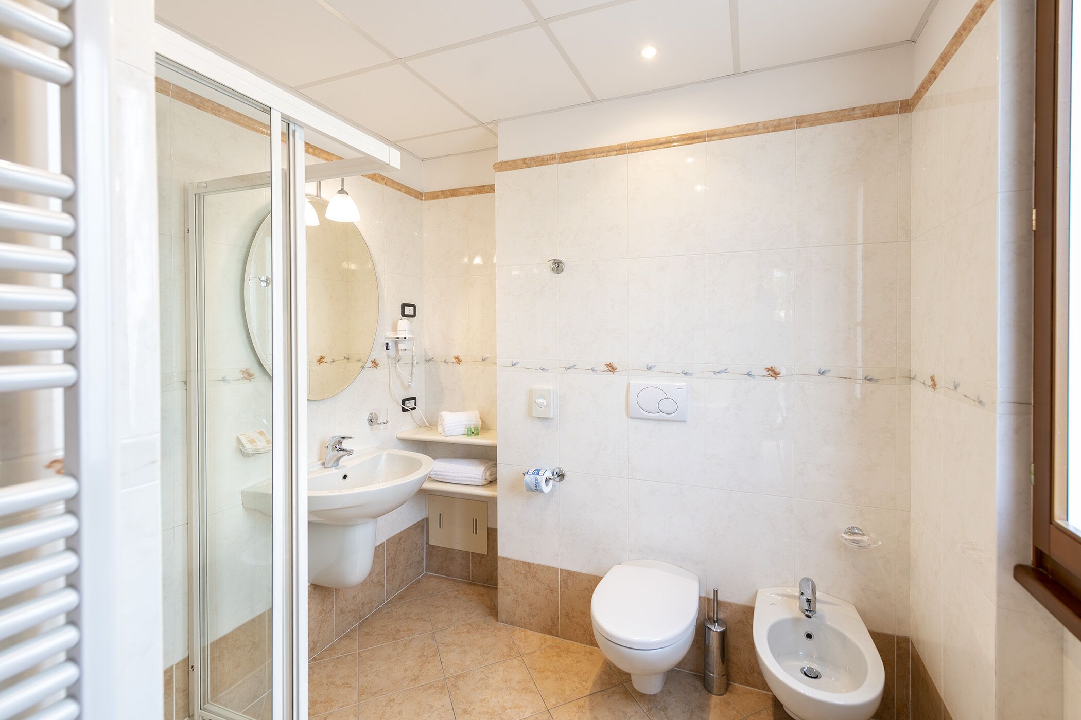 Ein modernes Badezimmer mit Duschkabine aus Glas, Waschbecken, Toilette und Bidet.