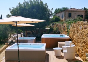 Ein Poolbereich mit zwei Whirlpools und Außenmöbeln.